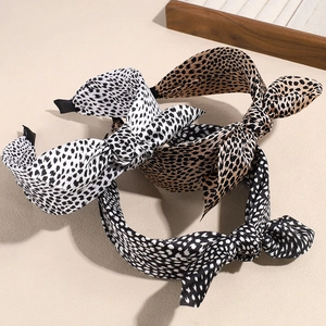 Three bow knot headbands with leopard and animal print patterns on a minimalist background