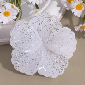 Detail einer glitzernden Blumen-Haarklammer in Weiß mit schimmernden Blütenblättern