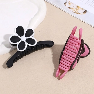 Pinces à cheveux élégantes avec papillon et fleurs en noir et rose sur un plateau