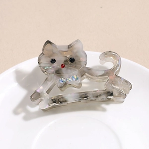 Détail de la pince à cheveux chat en acétate avec motif marbré et accents de strass