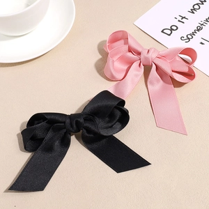 Elegant satin ribbon bow hair clips in black and pink with long tails for women