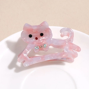 Détail d'une pince à cheveux chat en acétate rose avec texture marbrée et strass brillants