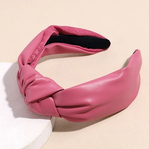 Close-up of pink PU leather knotted headband with black non-slip velvet inner lining