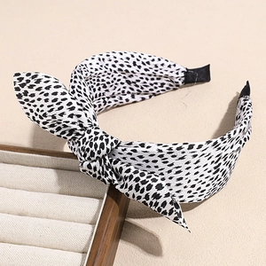 Detail of retro bow headband with black and white stone pattern and non-slip inner comb