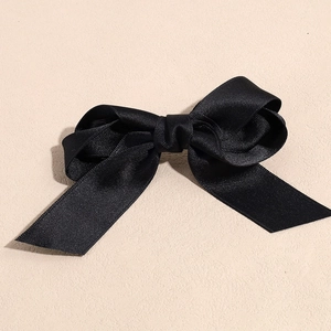 Detailed view of the black ribbon bow hair clip with elegant double-layered satin texture