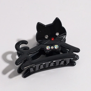 Détail d'une pince à cheveux chat noir avec strass colorés et une finition polie