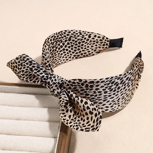 Close-up of leopard print bow headband on a display stand with non-slip wide band detail