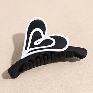 Détail de la pince à cheveux en forme de cœur, noir mat avec décoration de cœur blanc
