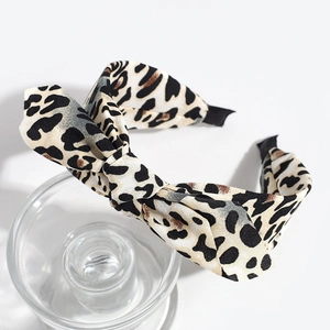Detailed view of leopard print bow headband with non-slip tips and fabric texture