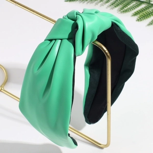Detail of green leather knotted headband with textured surface and black lining fabric