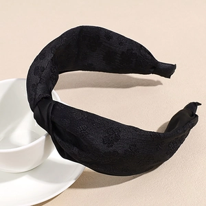 Détail du tissu jacquard noir et du design noué sur le bandeau large pour femmes