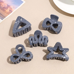 Detailed view of dark grey hair claws with white splatter pattern in various shapes