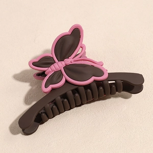 Vue détaillée de dessus d'une pince à cheveux papillon mate en marron foncé et rose pastel
