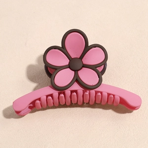 Détail de la pince à cheveux fleur rose et marron avec finition mate et dents solides
