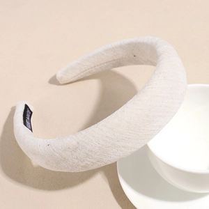 Détail d'un serre-tête vintage crème avec texture tissée et étiquette faite à la main