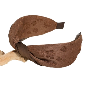 Serre-tête large noué en satin marron foncé avec broderie florale sur fond blanc neutre
