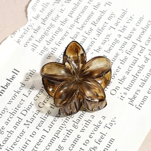Macro shot of an amber translucent resin hair claw with a 3D vintage floral design