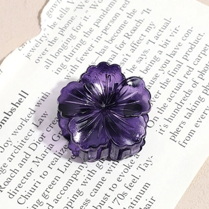 Detailed close-up of a purple flower-shaped hair claw clip with 3D petal texture