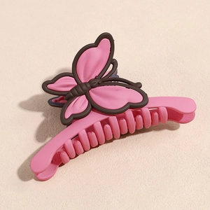 Détail de la pince à cheveux papillon rose avec finition mate et design à double aile