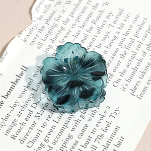 Detailed close-up of dark green flower hair claw clip with transparent resin finish
