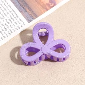 Detail einer kleinen lila Blumen-Haarklammer mit silberner Marmortextur und Metallfeder