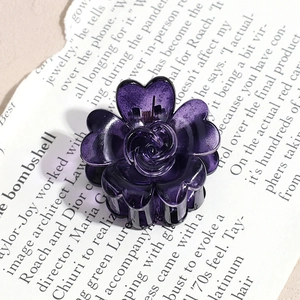 Detail view of deep purple resin flower hair claw clip with rose texture and heart petals