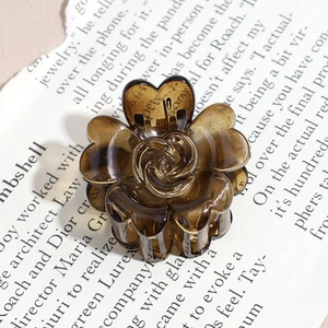 Detailed close-up of a vintage amber resin flower hair claw clip with heart-shaped petals