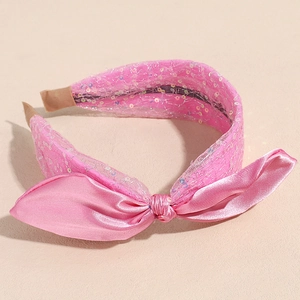 Detailansicht eines rosa Pailletten-Stirnbands mit Mesh-Schleife und Satin-Knoten