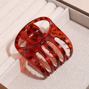 Detail of large leopard print hair claw clip in amber resin on a texture tray