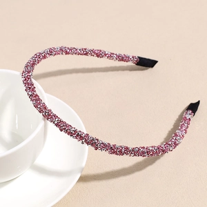 Detail eines rosa Kristallstirnbands mit glänzenden Strasssteinen und Stoffenden