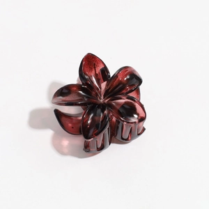 Detail of dark amber translucent flower hair claw clip with glossy resin finish