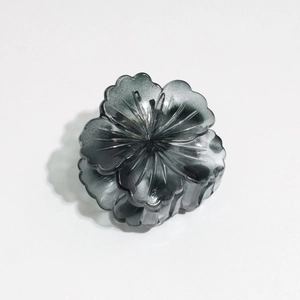 Detailed macro view of 3D layered flower hair claw clip in translucent dark grey resin