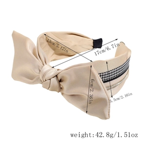 Detail eines beigen Satin-Haarreifs mit Strasssteinen und Hahnentritt-Muster