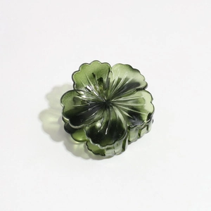 Detail view of a dark green floral claw clip with resin petals and retro texture