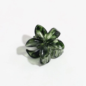 Macro detail of translucent deep green flower hair claw clip with floral resin petals