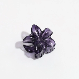 Macro view of purple floral claw clip with a glossy translucent resin finish for hair