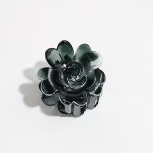 Detailed view of dark grey rose hair claw with heart-shaped petals in glossy acetate