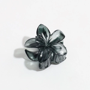 Detail of a dark gray translucent flower hair claw clip with ink marble texture finish
