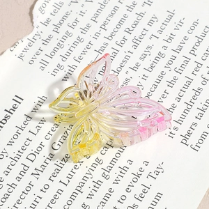 Détail de la pince à cheveux papillon évidée avec dégradé jaune et violet