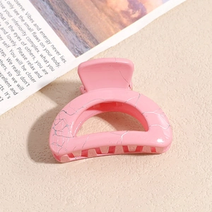 Detailansicht der kleinen rosa Haarspange mit silberner Marmorierung und Metallfeder
