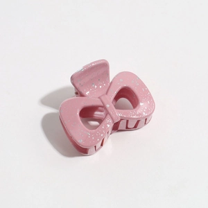 Close-up of pink matte bow hair claw clip with silver speckled finish and spring detail