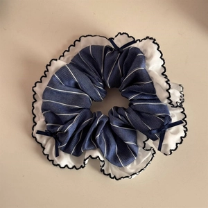Detailed shot of blue striped scrunchie with white lace trim and dark navy ribbon bows