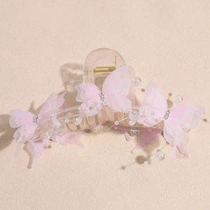 Detail of a clear hair claw clip featuring pink mesh butterflies and beaded pearls