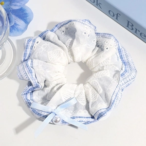 Detail of light blue plaid scrunchie with lace trim, ribbon bow and pearl bead