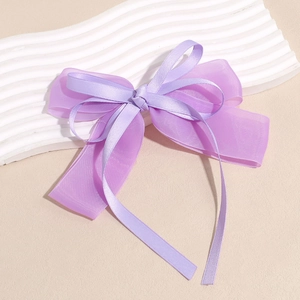 Close-up detail of double-layer purple organza and satin ribbon bow hair accessory