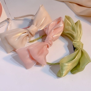 Tres diademas de lazos elegantes en champán, rosa y verde con acabado satinado perlado