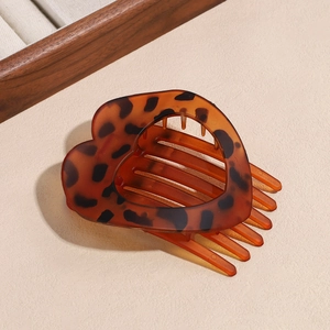Macro shot of heart-shaped leopard print hair comb with polished resin texture