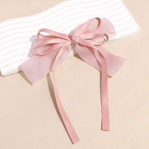 Detailed close-up of pink double-layered bow hair clip with elegant streaming ribbons