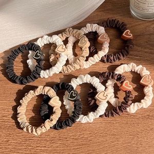 Set of 10 minimalist heart-shaped scrunchies in earth tones on a wooden surface