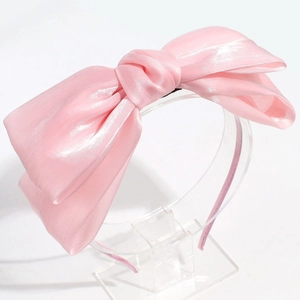 Detalle de diadema de satén rosa con tela sedosa y una estructura de estilo elegante